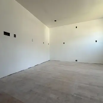 Freshly plastered walls and ceiling in a bright unfinished room